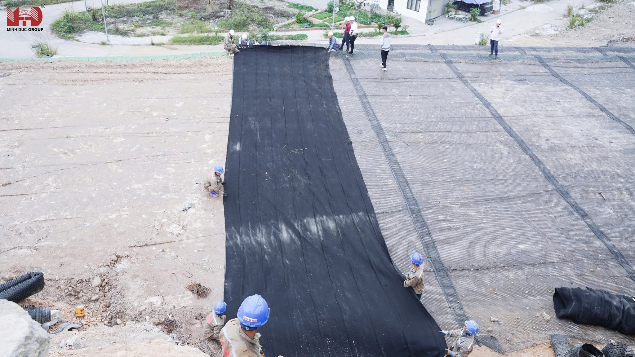 Toàn cảnh công tác rải cuộn vải địa kỹ thuật khổ lớn trên nền móng công trình của Minh Đức EC 